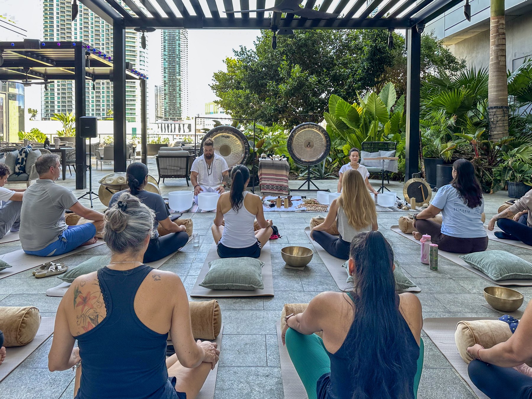 Participants seated in a circle facing the gongs